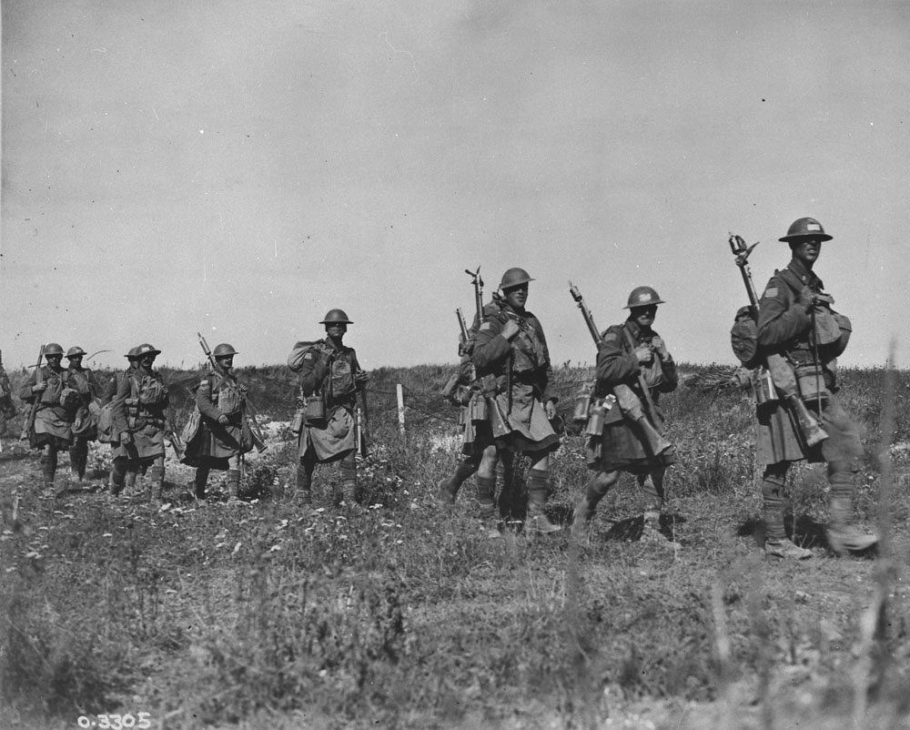 Personnel of the 42nd Regiment (13th Battalion, Royal Highlanders of Canada) moving up to the attack on Cambrai in the early morning. Additional later annotation: The soldier third from right is Private Roy Edward Henley 670194/514204 of "B" Company, 42nd Regiment. MIKAN No. 3355935