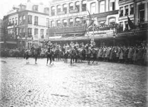 General Sir Arthur Currie, General Loomis and Officers in Grand Place, Mons, November 11th, 1918, taking the salute of the March past. MIKAN No. 3522365