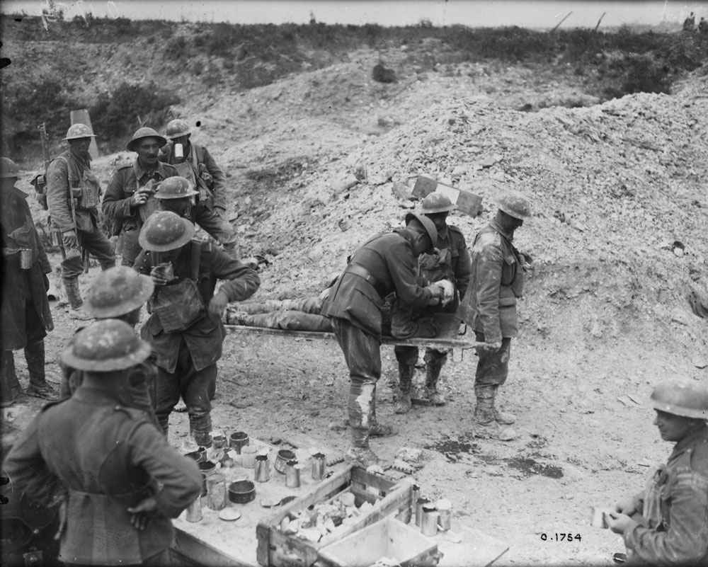 Canadian Padre gives wounded Canadian hot tea at a Soup Kitchen, only a 1/4 mile from the Front Line at Hill 70. MIKAN No. 3395501