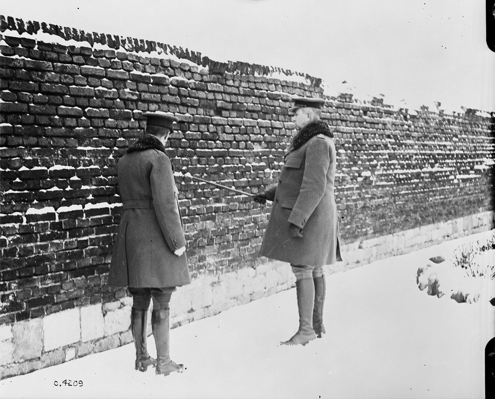 Gen. Currie visits Andenne where 200 civilians were shot by Germans against this wall, 21st August 1914. MIKAN No. 3403396