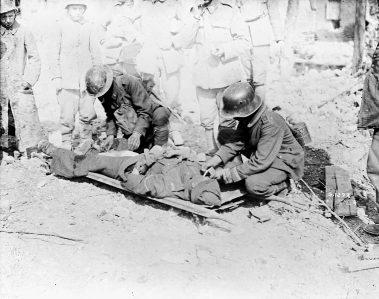 German N.C.O. prisoner lights a cigarette for a wounded Canadian at the taking of Arleux. MIKAN No. 3194801