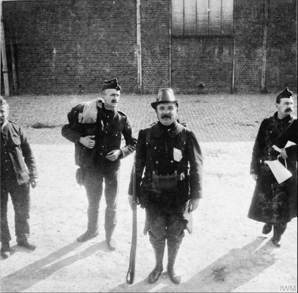 Belgian Civil Guard watching the departure by train of the 2nd Battalion, Scots Guards, from Zeebrugge for Bruges, 7 October 1914.